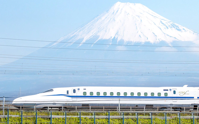 Shinkansen train passing in front of Mount Fuji, Japan.
