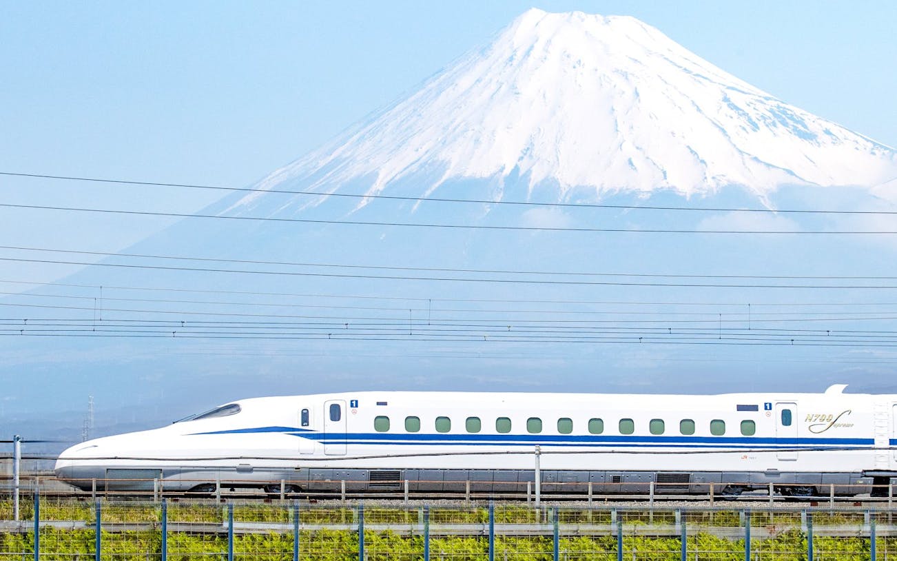 Shinkansen train passing in front of Mount Fuji, Japan.