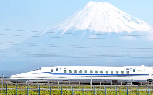 Shinkansen train passing in front of Mount Fuji, Japan.