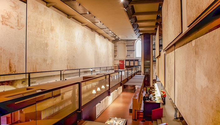 Interior view of the Sinopie Museum in Pisa showcasing frescoes and modern architecture.