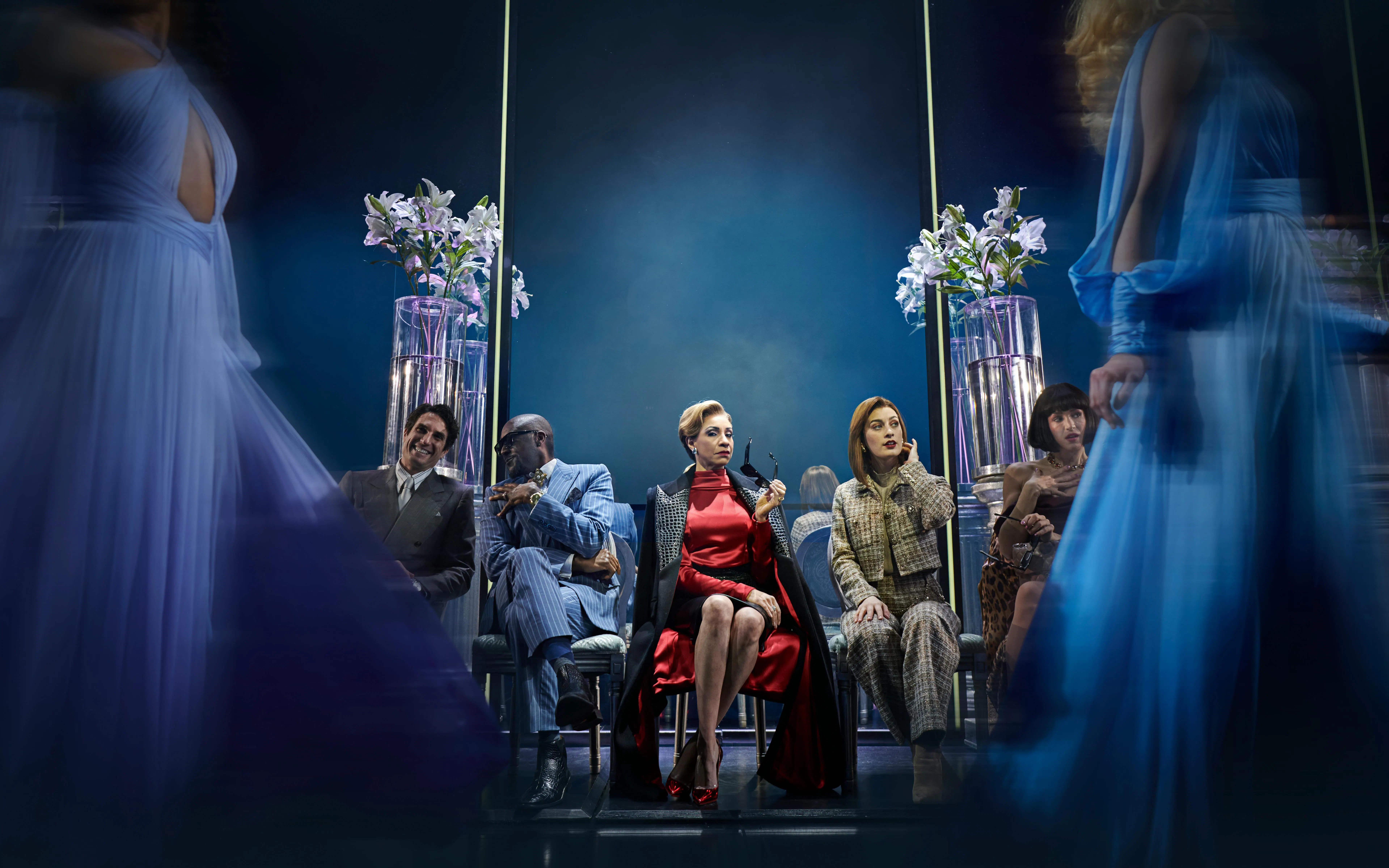 Performance scene from The Devil Wears Prada in Hamburg, featuring seated characters and elegant costumes.