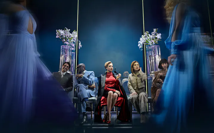 Performance scene from The Devil Wears Prada in Hamburg, featuring seated characters and elegant costumes.