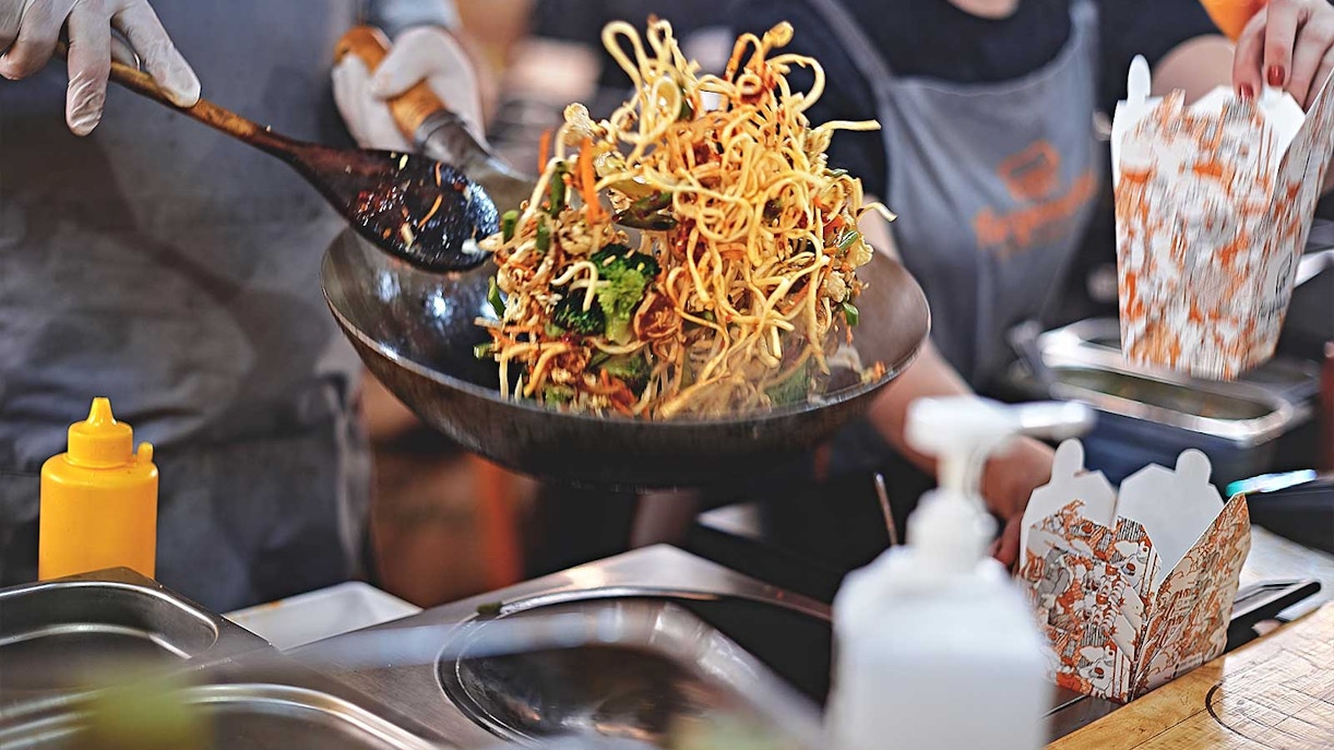 Stir-fried noodles being prepared at a street food stall during Bangkok Night Bike Tour.
