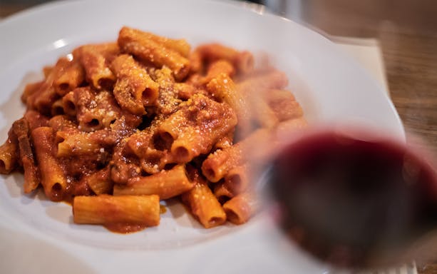 Pasta with tomato sauce and a glass of red wine on a Trastevere food tour.