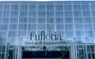 Eufloria Gardens & Sculpture Park entrance with glass facade.