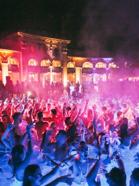 Crowd enjoying a vibrant bath party at night in Budapest.