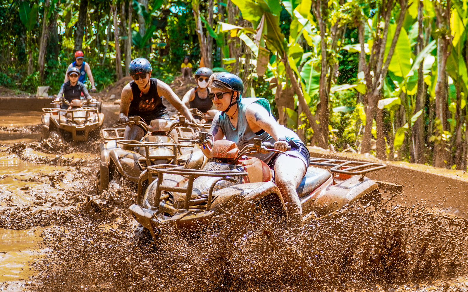 ATV riders navigating muddy terrain in Ubud jungle.