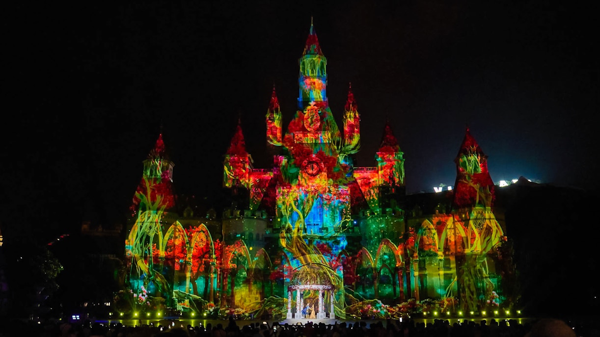 Light and sound show at Vinpearl, Nha Trang, illuminating a castle with vibrant projections.