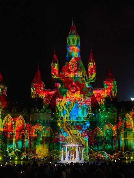 Light and sound show at Vinpearl, Nha Trang, illuminating a castle with vibrant projections.