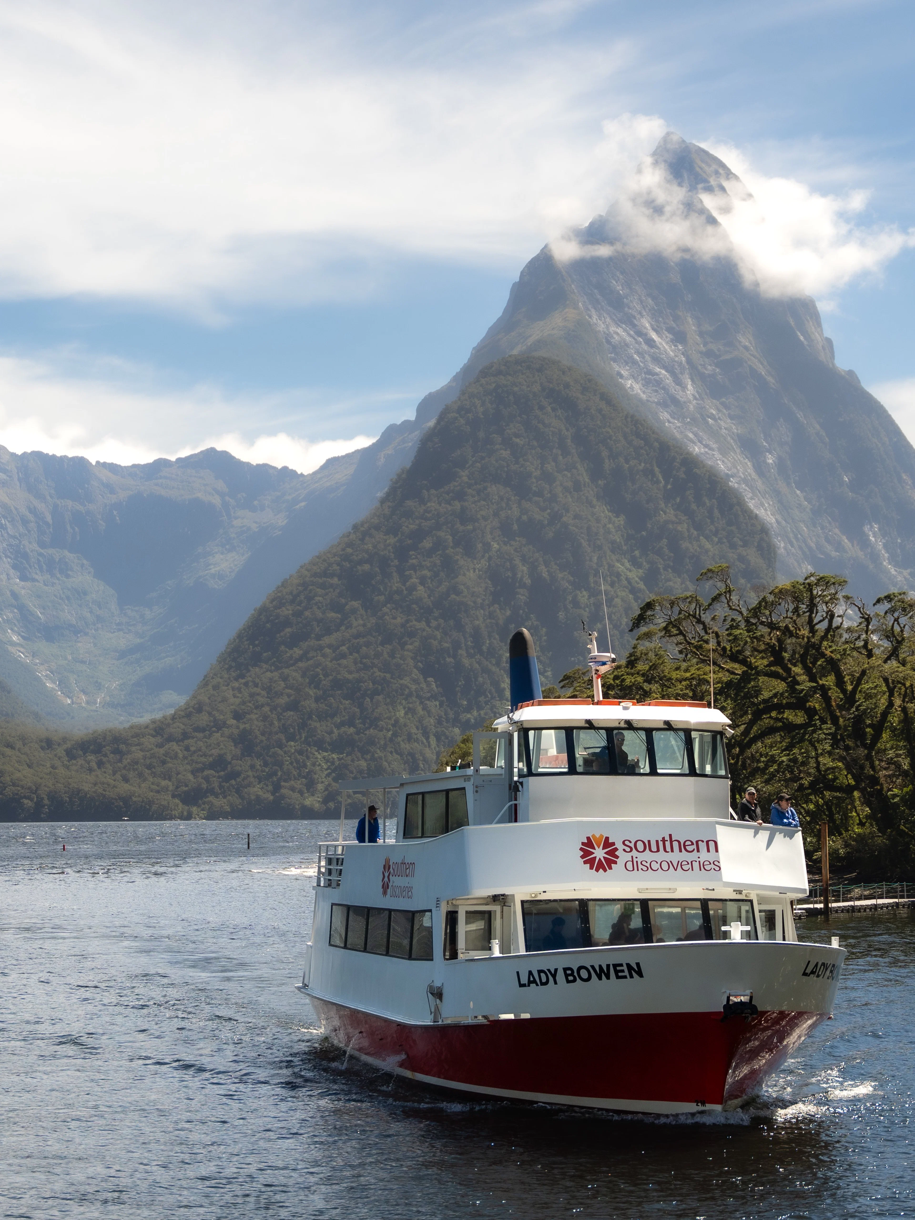 Cruise boat on Milford Sound with Mitre Peak in the background, New Zealand.