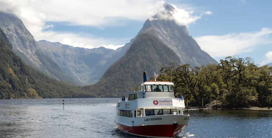 Cruise boat on Milford Sound with Mitre Peak in the background, New Zealand.