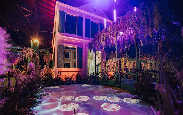 Monet’s Garden Immersive Exhibition with illuminated bridge and projected water lilies.