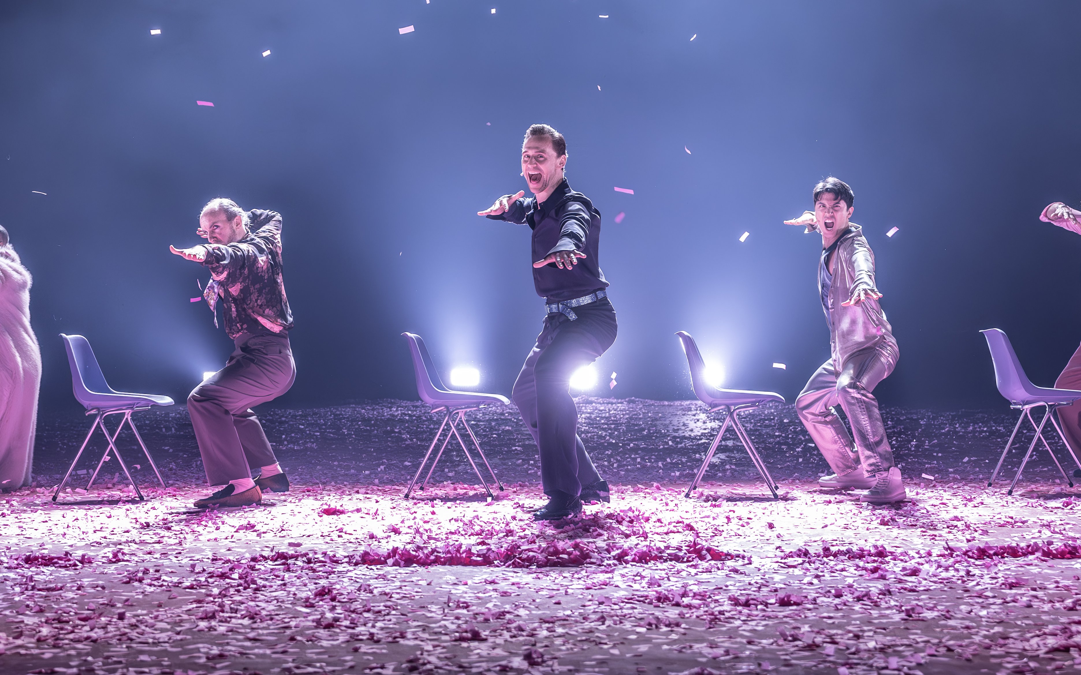 Actors performing Much Ado About Nothing on Broadway stage with chairs and confetti.