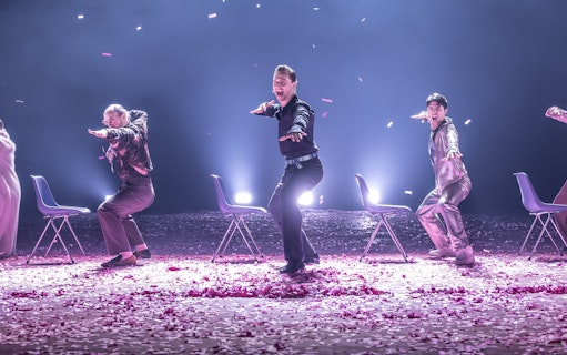 Actors performing Much Ado About Nothing on Broadway stage with chairs and confetti.