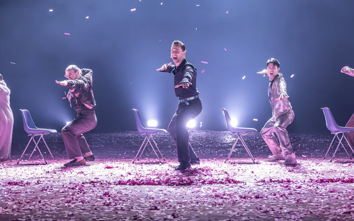 Actors performing Much Ado About Nothing on Broadway stage with chairs and confetti.