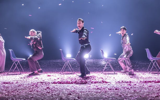 Actors performing Much Ado About Nothing on Broadway stage with chairs and confetti.