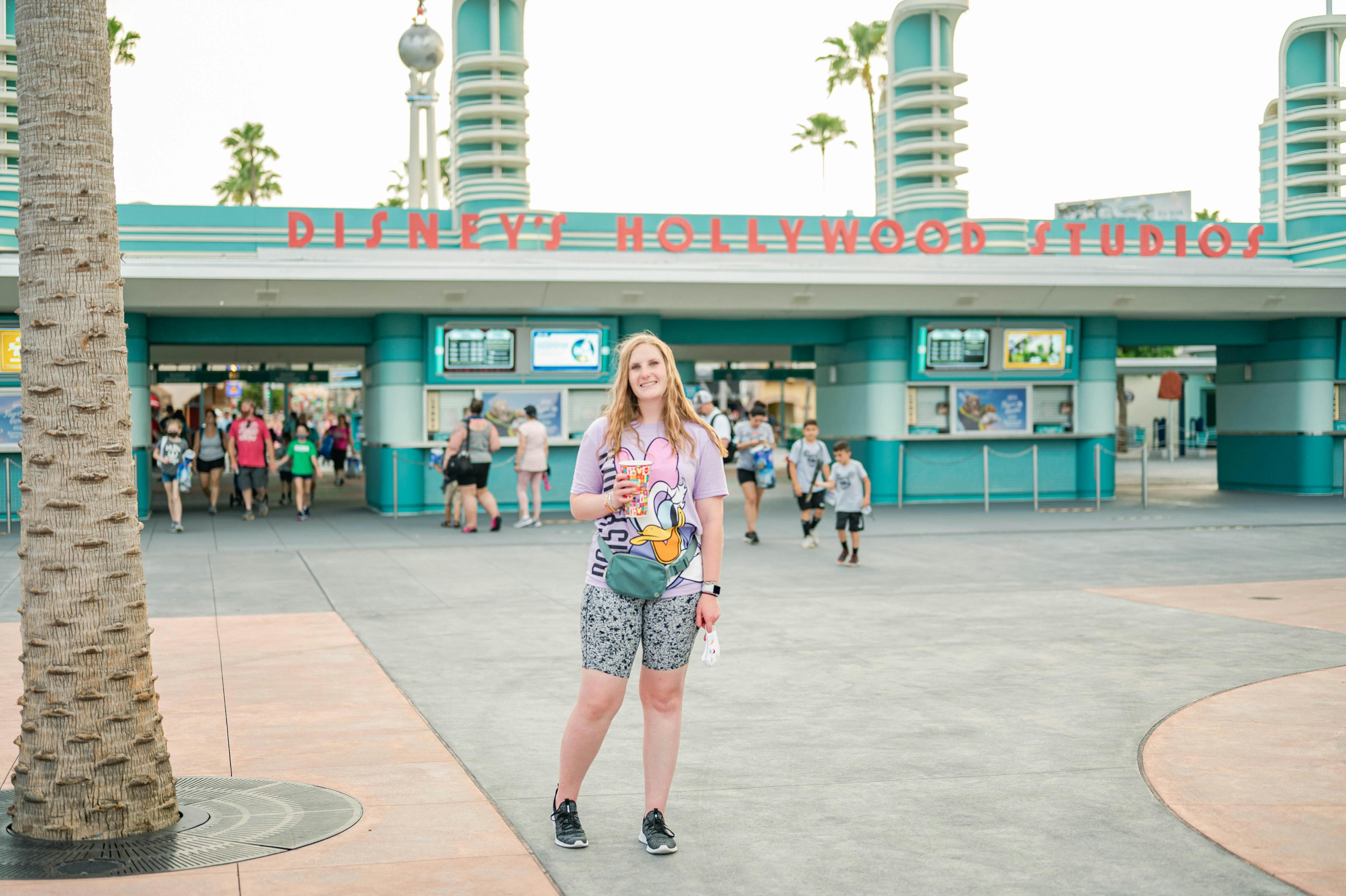 Woman standing in front of Disney Hollywood Studios entrance, Walt Disney World Resort, Orlando.