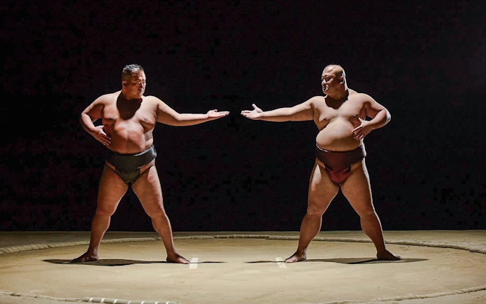 Sumo wrestlers facing off at The Sumo Hall Hirakuza in Osaka.