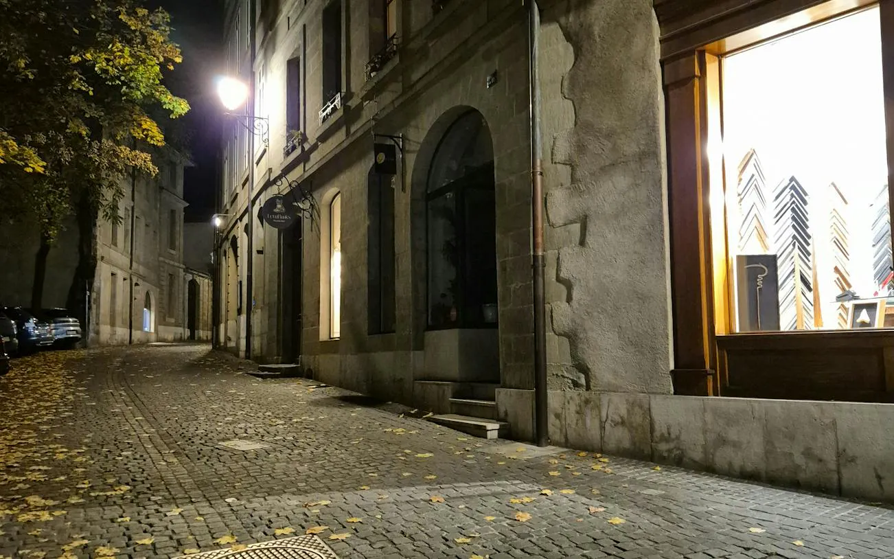 Cobblestone street in Geneva at night, part of the Murder Mystery city exploration game.