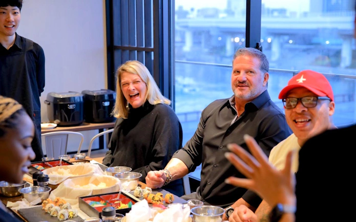 Participants enjoying a sushi-making class in Osaka with an English-speaking instructor.