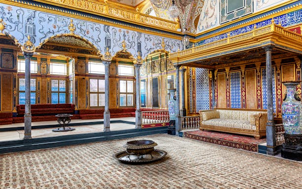 Interior of Topkapi Palace's ornate room, Istanbul, featuring intricate designs and luxurious decor.