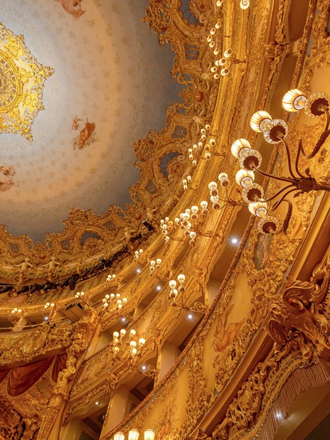 Teatro La Fenice Venice theatre ceiling with ornate chandeliers and detailed gold interior.