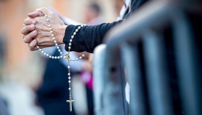 Pilgrim praying inside Notre Dame during mass.