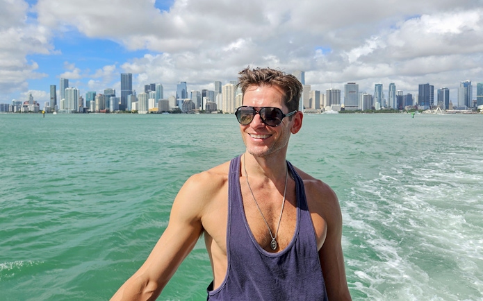 Man enjoying Miami skyline view from luxury yacht cruise.