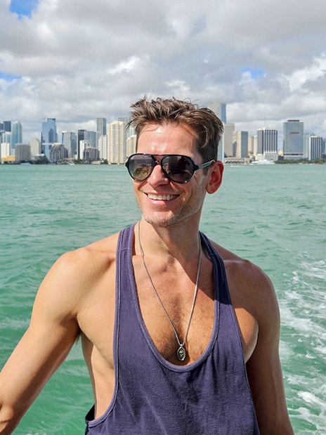 Man enjoying Miami skyline view from luxury yacht cruise.