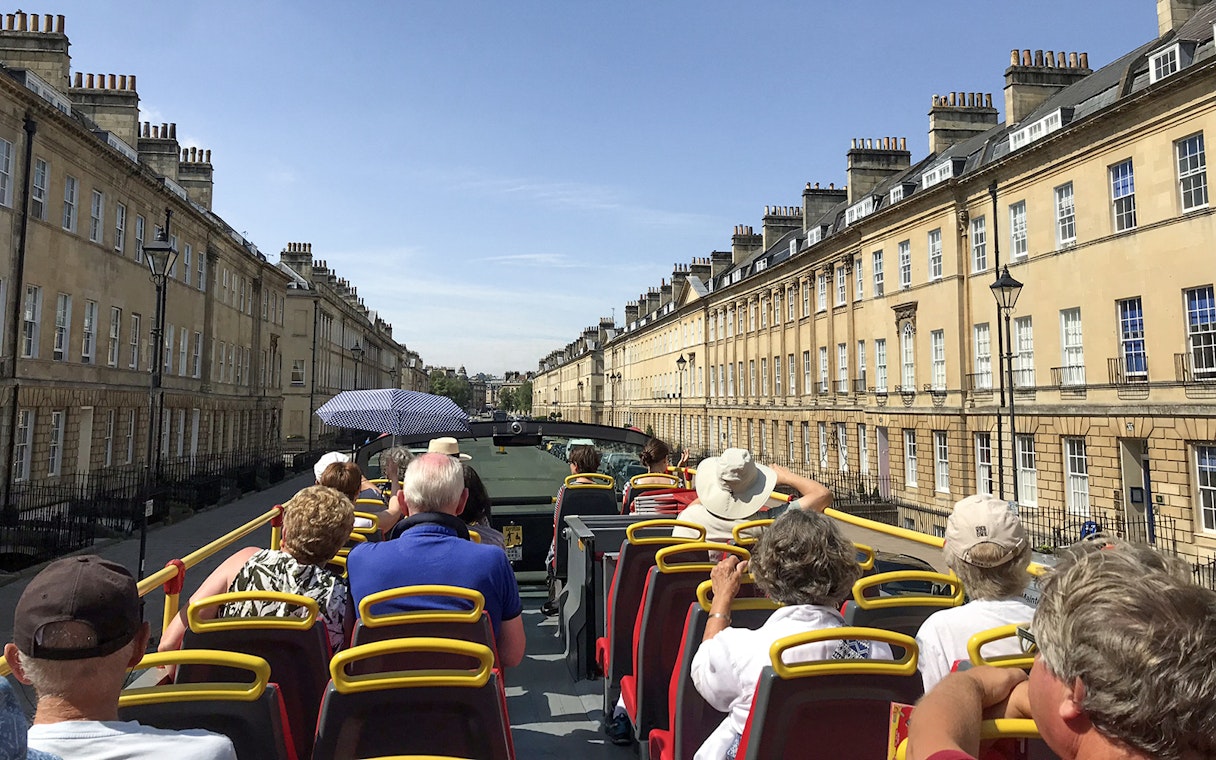 Open-top bus tour through Georgian architecture in Bath, England.