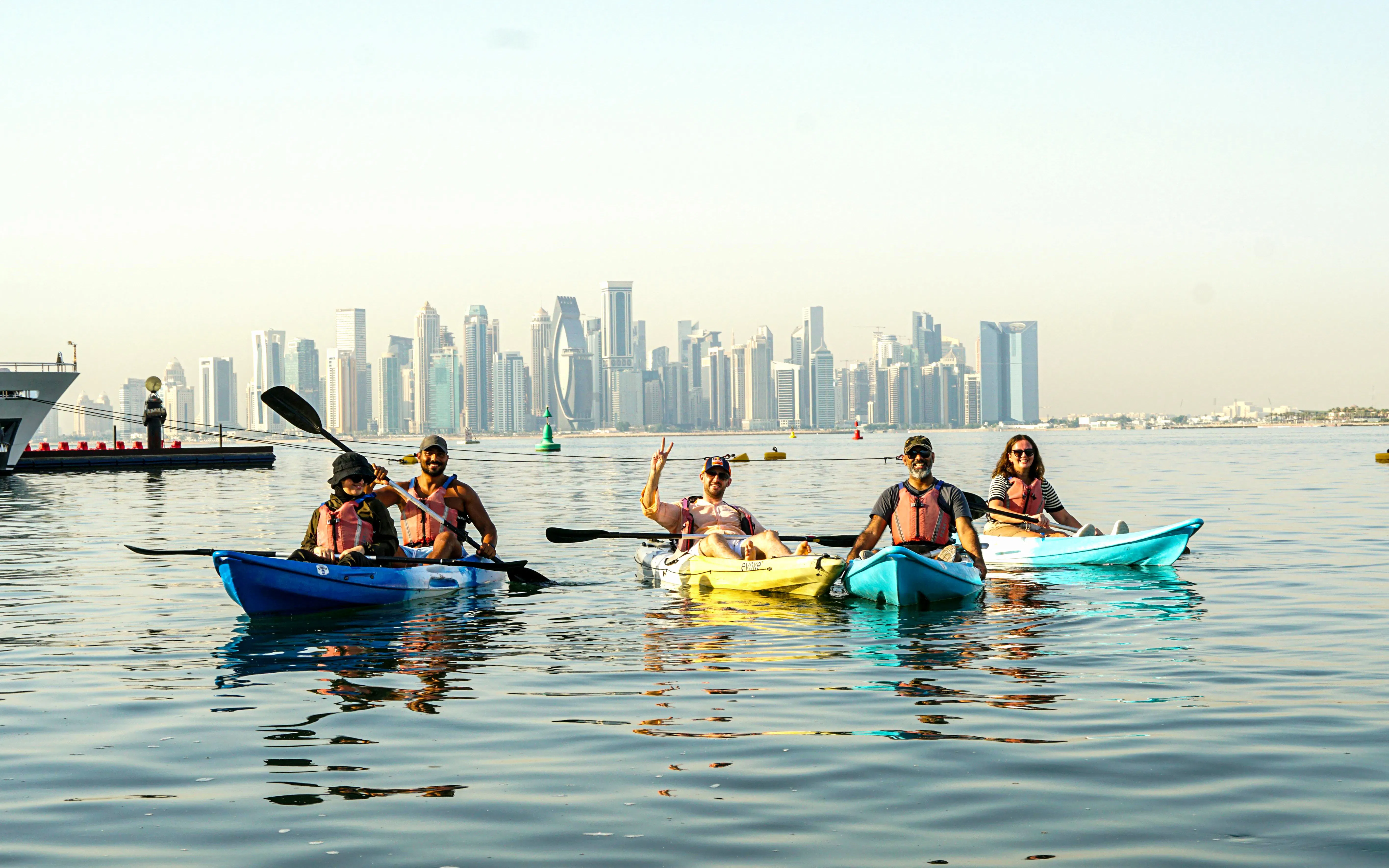 Kayakers on The Pearl Guided Kayak Tour in Doha with city skyline in background.