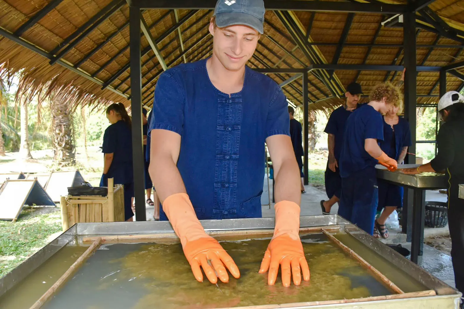 Man participating in elephant poo paper workshop in Krabi, Thailand.