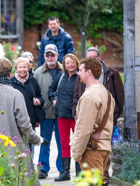 Tour group in Stratford garden during Stratford, Oxford, Cotswolds & Warwick Castle tour.