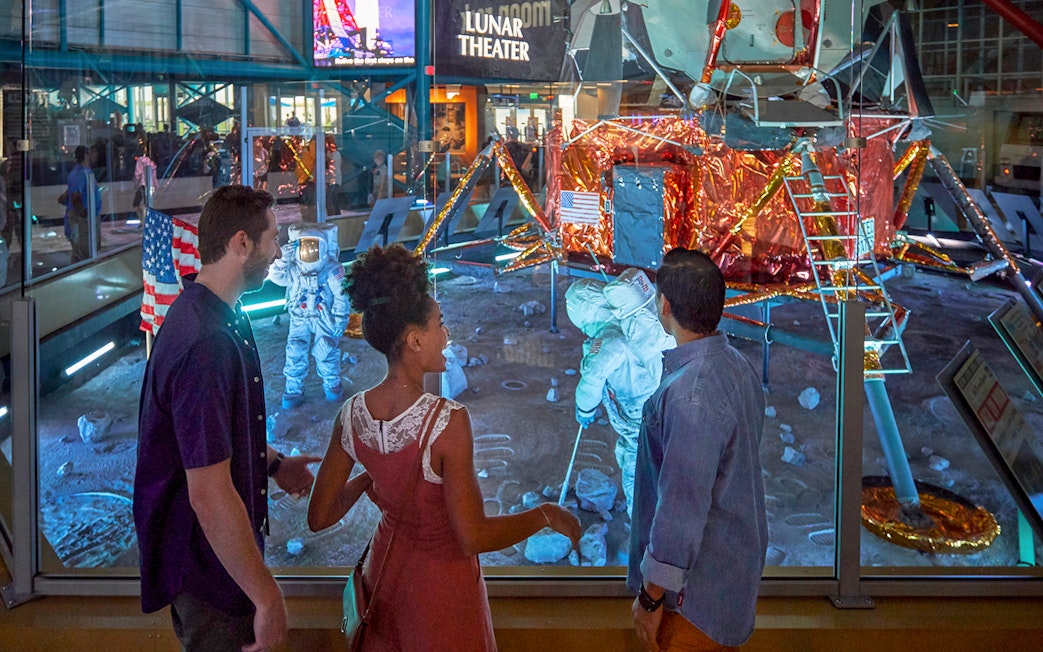 Visitors observing lunar module exhibit at Kennedy Space Center.