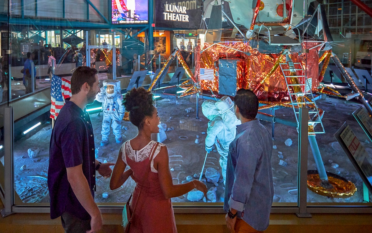 Visitors observing lunar module exhibit at Kennedy Space Center.