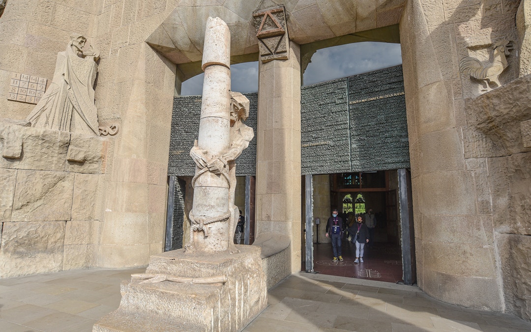 Sculpture and entrance detail at Sagrada Familia, Barcelona, during a guided tour.