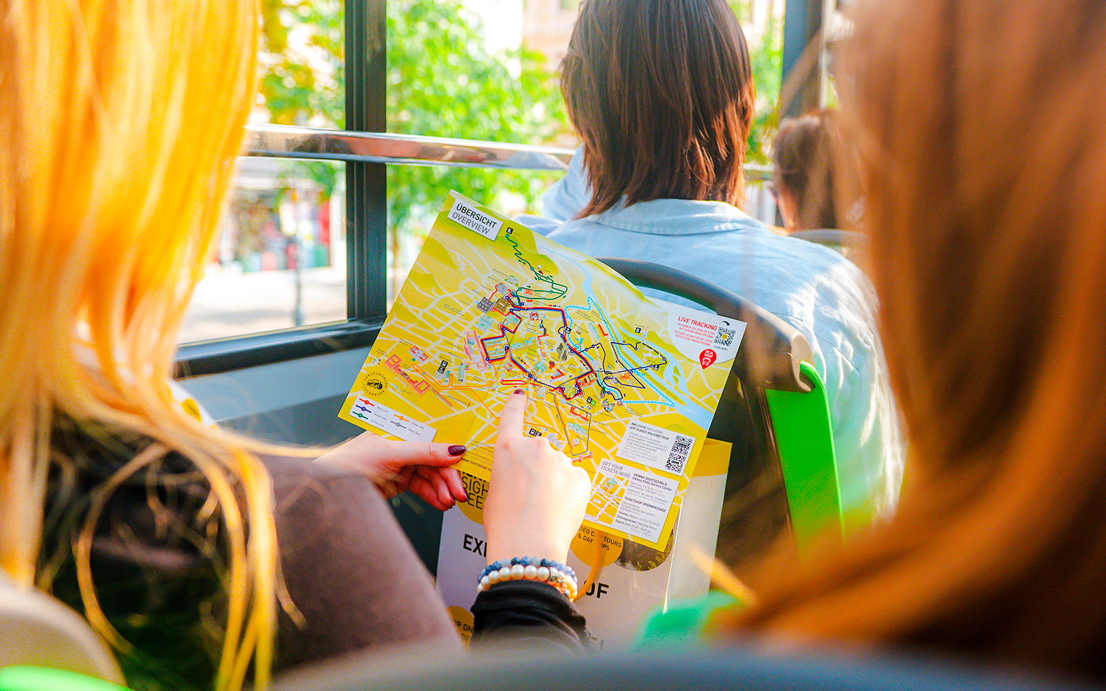Tourists on Vienna sightseeing bus holding route map.