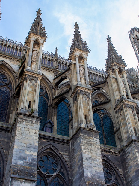 Notre-Dame de Reims, France, showcasing Gothic flying buttresses and detailed stone carvings.
