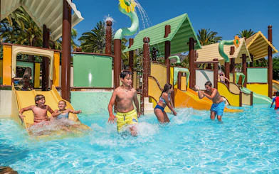 Kids enjoying slides and water play in Children's Paradise pool at Aqualand Torremolinos.