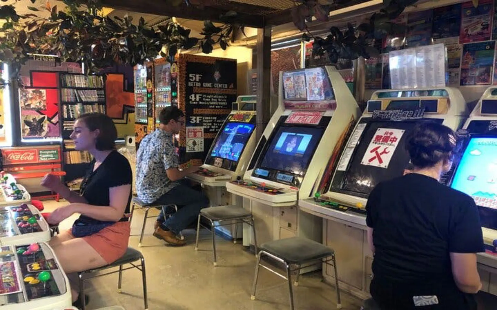 People playing arcade games in a retro game center in Akihabara, Tokyo.