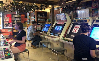 People playing arcade games in a retro game center in Akihabara, Tokyo.