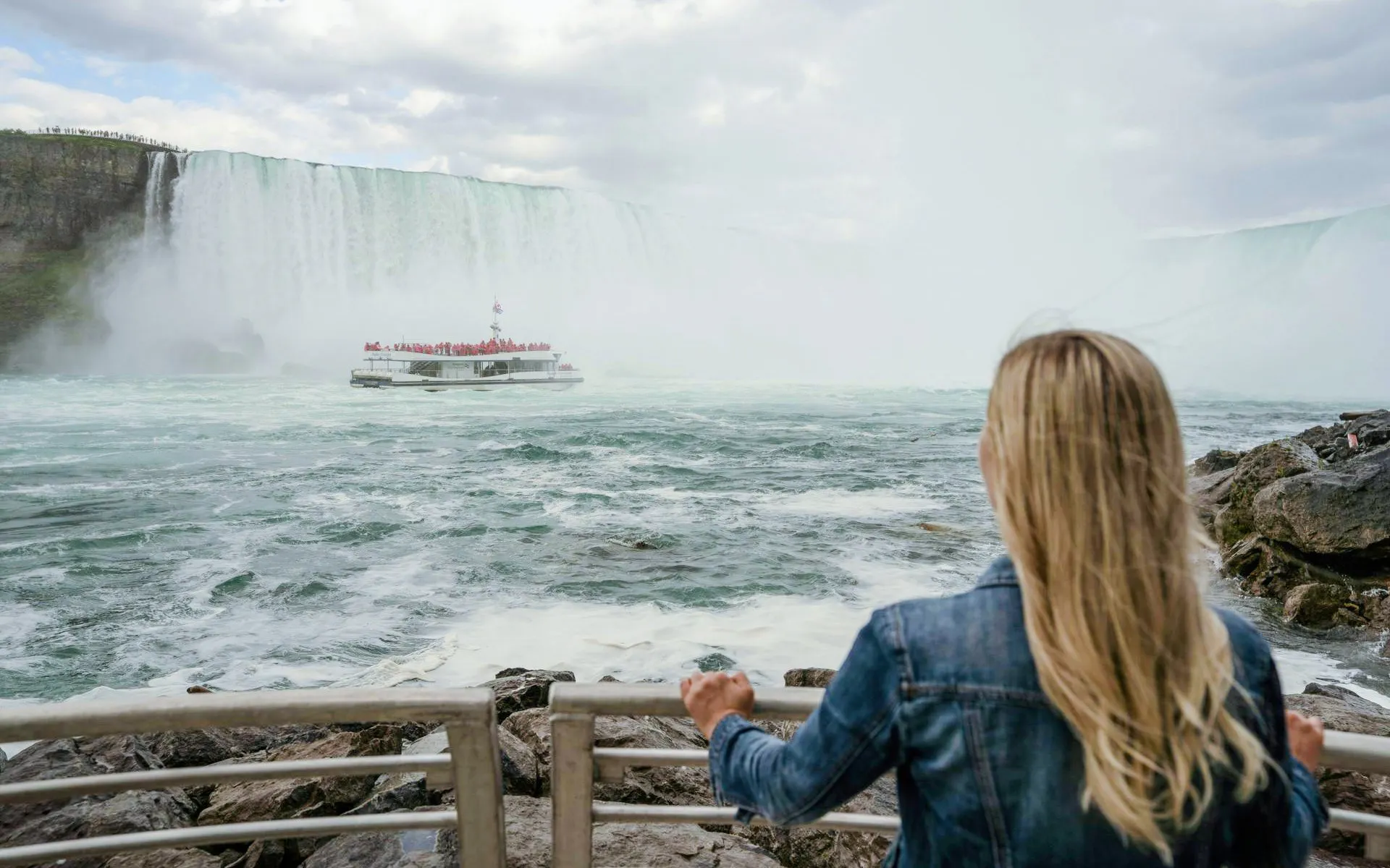 Tourist viewing Niagara Falls with boat approaching, Canada.