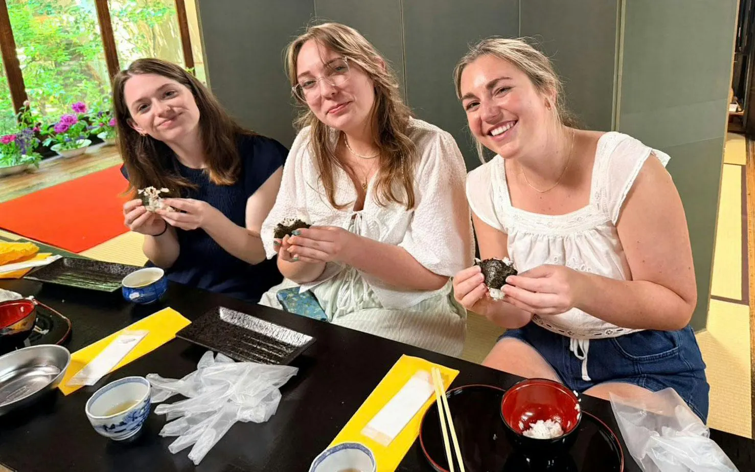 Friends making onigiri at a traditional Japanese cooking class in Kyoto.