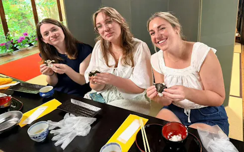 Friends making onigiri at a traditional Japanese cooking class in Kyoto.