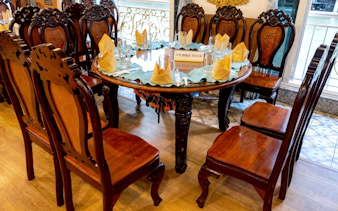 Elegant dining setup on Saigon river cruise with wooden chairs and table settings.