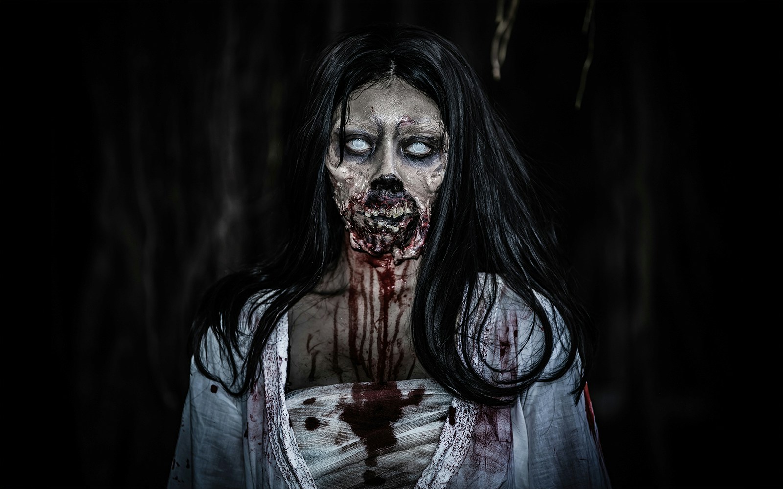 Woman in ghost bride costume with blood for Halloween event.