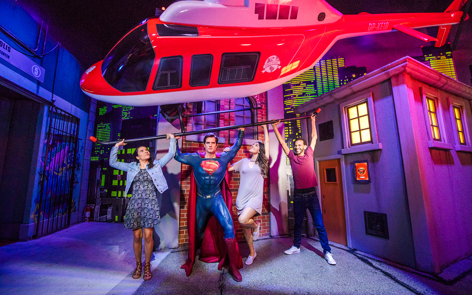 Superman figure lifting helicopter with visitors at Madame Tussauds Orlando.