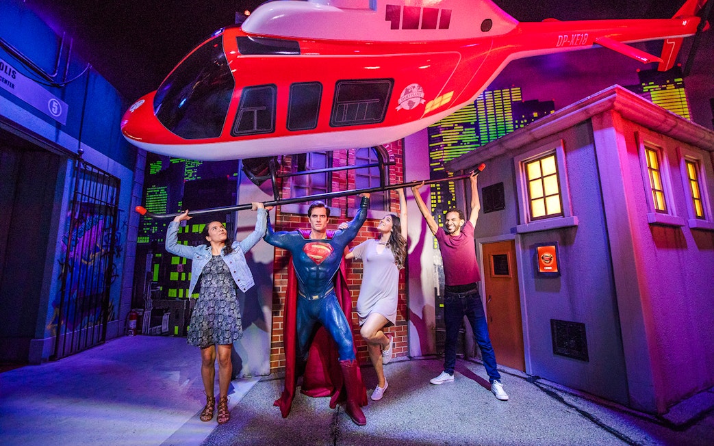 Superman figure lifting helicopter with visitors at Madame Tussauds Orlando.