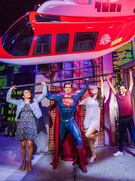Superman figure lifting helicopter with visitors at Madame Tussauds Orlando.