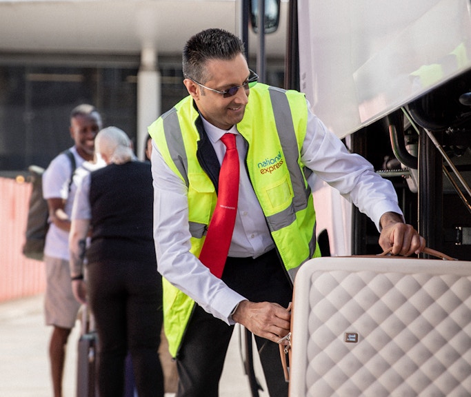 Bus staff loading luggage for Stansted Airport to London Victoria route.